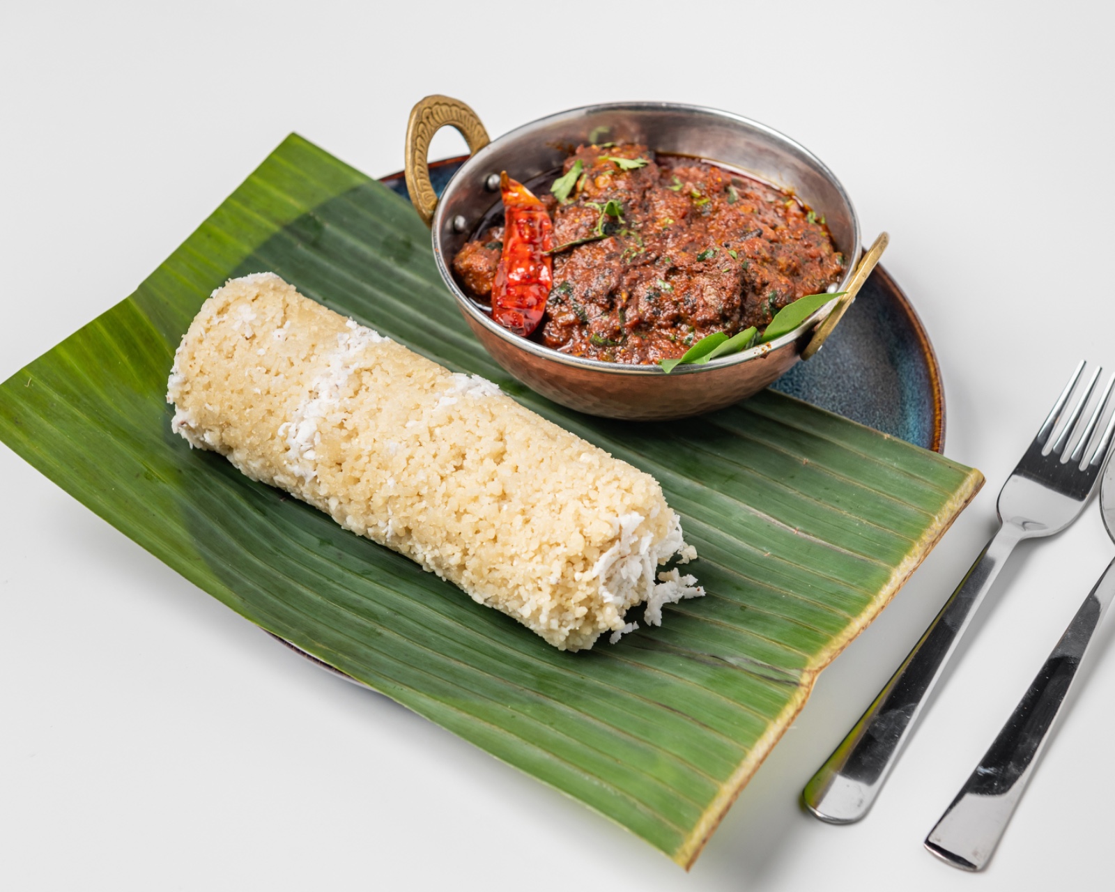 Puttu with Chicken/Lamb - Traditional steamed rice flour cylinders served with spicy chicken or lamb curry